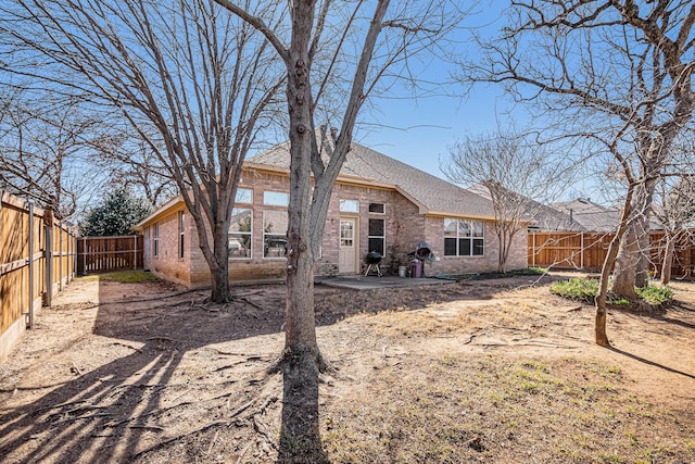 813 Royal Oak Ln, Burleson, TX 76028 - back of house with brick siding, a fenced backyard, a patio area, and roof with shingles