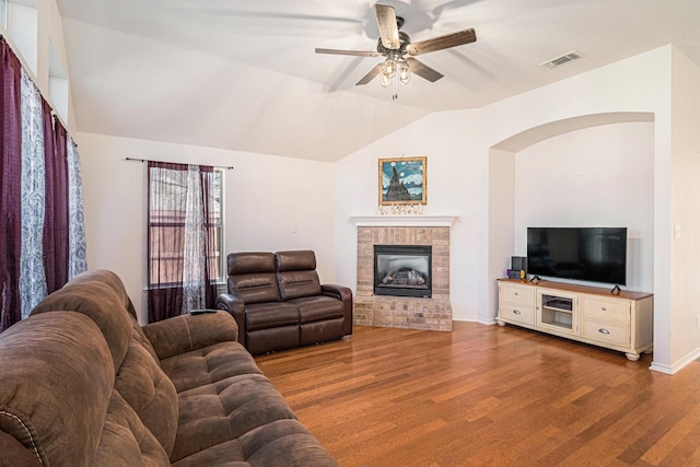 813 Royal Oak Ln, Burleson, TX 76028 - living area featuring wood finished floors, a ceiling fan, vaulted ceiling, a fireplace, and arched walkways
