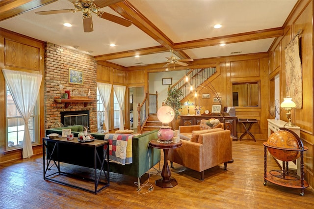 3908 Jamestown Pl, Plano, TX 75023 - living room featuring ceiling fan, wood finished floors, stairs, a fireplace, and wood walls