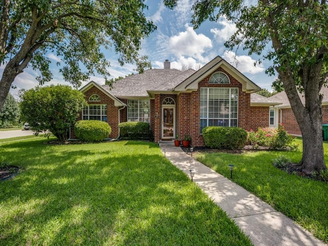 320 Willow Stone St, Denton, TX 76207 - view of front of house featuring a front lawn, brick siding, a chimney, and a shingled roof