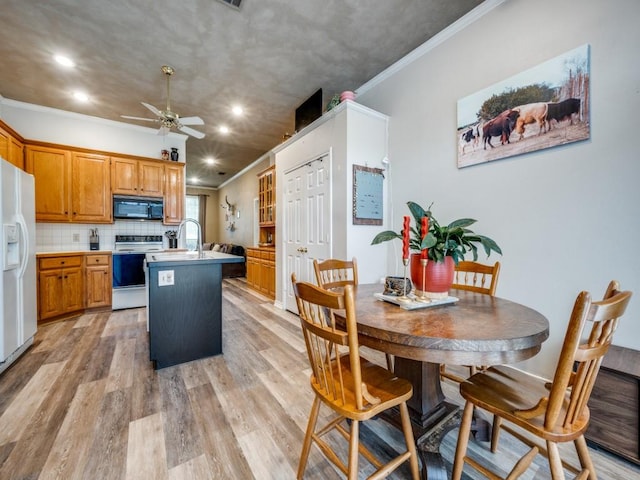 320 Willow Stone St, Denton, TX 76207 - kitchen with white appliances, ornamental molding, a kitchen island with sink, a ceiling fan, and light wood-style floors