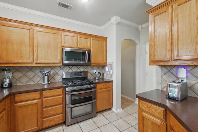 1900 Cassandra Ct, Fort Worth, TX 76131 - kitchen with stainless steel appliances, dark countertops, arched walkways, decorative backsplash, and light tile patterned flooring