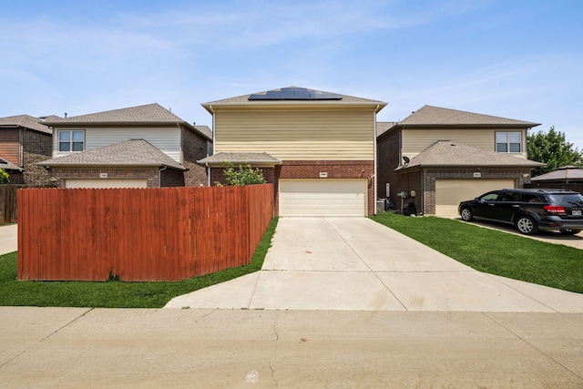 5005 Dominion Blvd, Irving, TX 75038 - traditional-style home featuring roof mounted solar panels, an attached garage, driveway, and brick siding