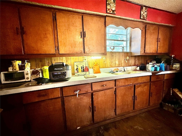 903 College St, Sulphur Springs, TX 75482 - kitchen with light countertops, brown cabinets, and dark wood-style flooring
