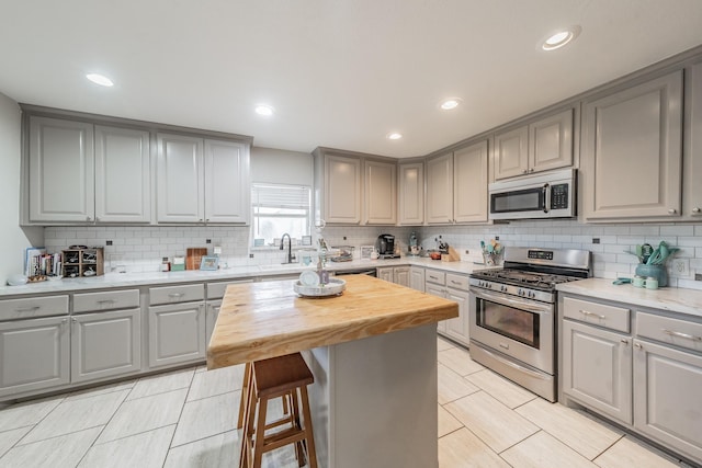 300 E Shoemaker St, Decatur, TX 76234 - kitchen featuring stainless steel appliances, gray cabinets, butcher block countertops, tasteful backsplash, and recessed lighting