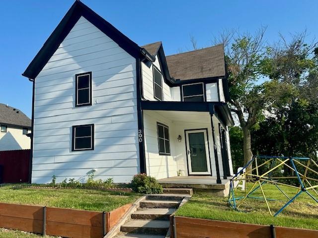 300 E Shoemaker St, Decatur, TX 76234 - view of front facade with a playground, covered porch, and a front yard