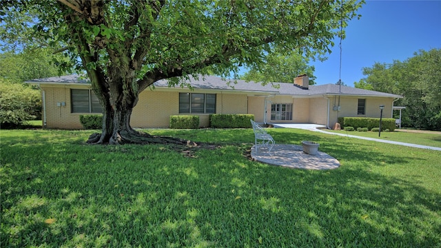 1106 Central Ave, Bowie, TX 76230 - ranch-style house with a patio, brick siding, a front yard, and a chimney