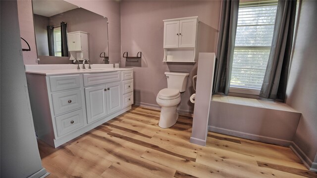 1106 Central Ave, Bowie, TX 76230 - bathroom with toilet, vanity, wood finished floors, and baseboards