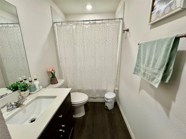 1013 Euston St, Denton, TX 76209 - full bathroom with wood finished floors, toilet, vanity, baseboards, and a shower with shower curtain