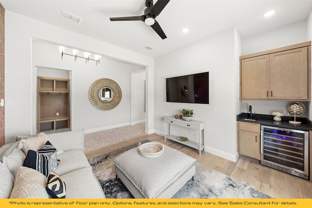 1044 Olympic Dr, Rockwall, TX 75087 - living area with wine cooler, bar with sink, a ceiling fan, light wood-style flooring, and baseboards