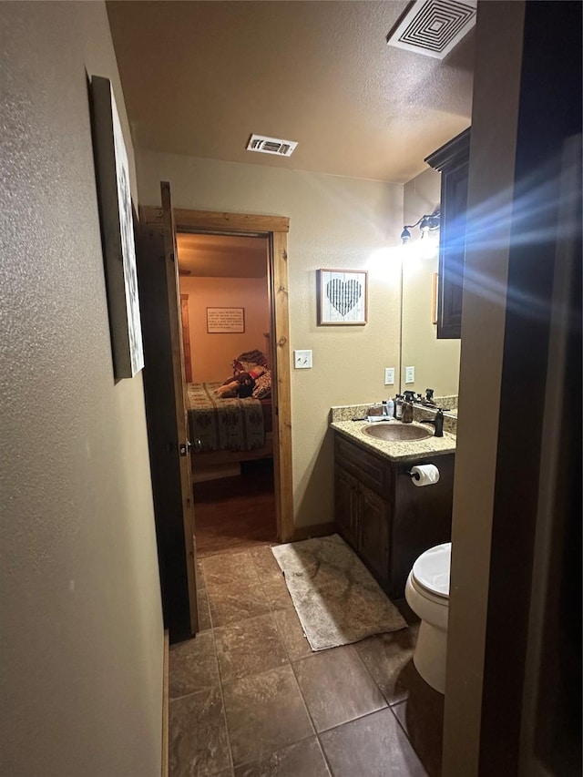 285 NE 5th St, Bogata, TX 75417 - ensuite bathroom with vanity, toilet, and tile patterned floors