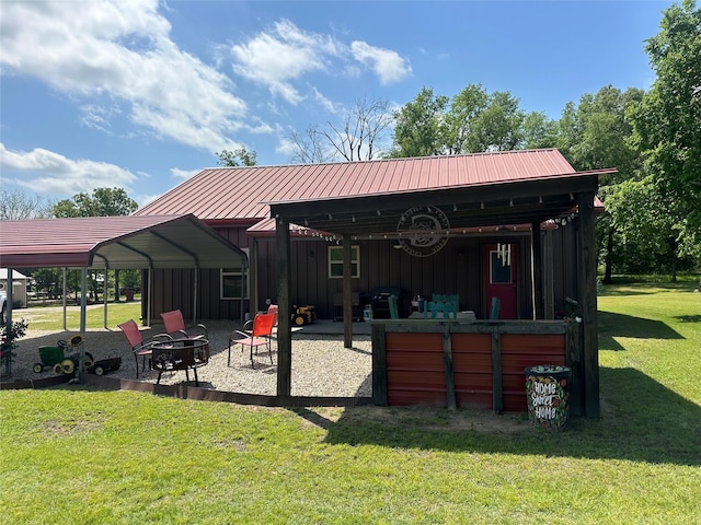 285 NE 5th St, Bogata, TX 75417 - back of house with board and batten siding, a fire pit, a yard, a patio area, and metal roof