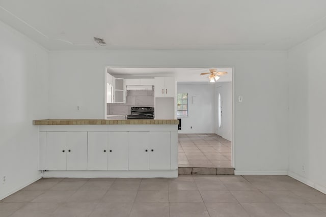 84 Natchez Rd, Pottsboro, TX 75076 - kitchen featuring black range oven, white cabinets, a peninsula, ceiling fan, and baseboards