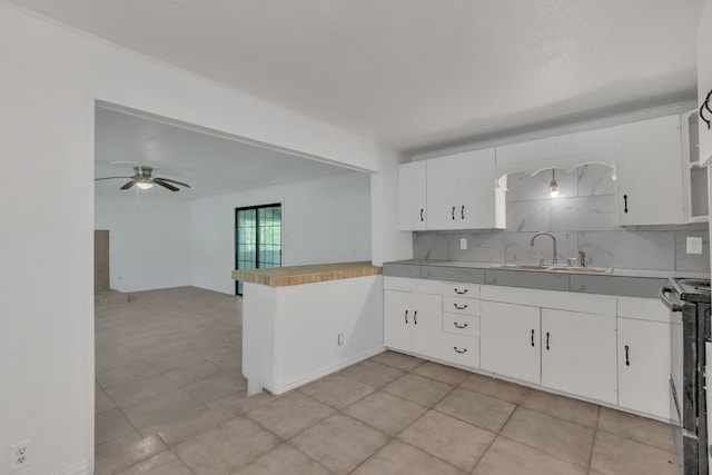 84 Natchez Rd, Pottsboro, TX 75076 - kitchen featuring a sink, ceiling fan, a peninsula, white cabinetry, and tasteful backsplash