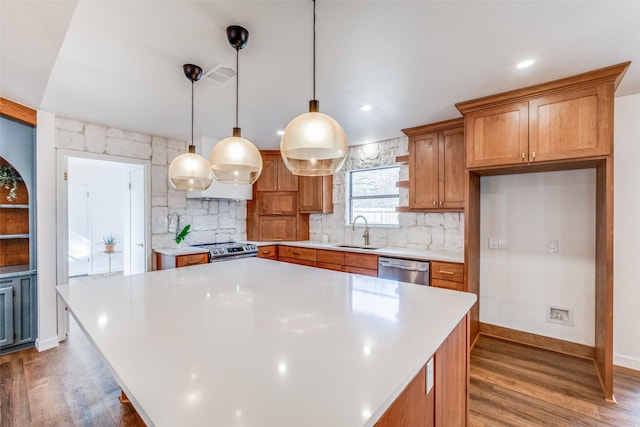 130 Holland Dr, Denison, TX 75020 - kitchen with a sink, appliances with stainless steel finishes, wood finished floors, light countertops, and brown cabinetry