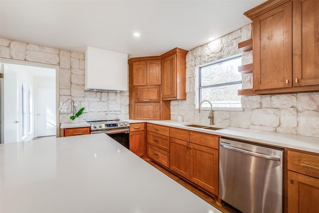 130 Holland Dr, Denison, TX 75020 - kitchen featuring appliances with stainless steel finishes, a sink, light countertops, tasteful backsplash, and brown cabinets