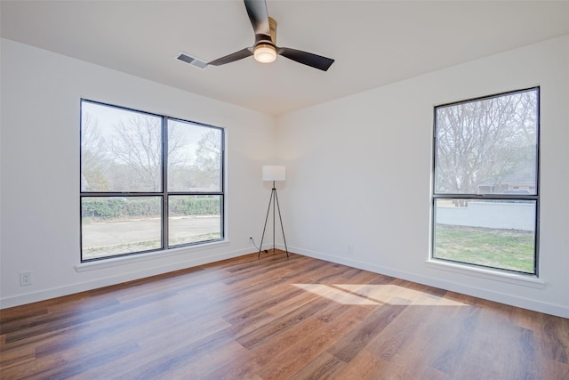 130 Holland Dr, Denison, TX 75020 - spare room featuring wood finished floors, plenty of natural light, and baseboards