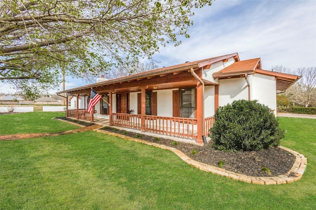 130 Holland Dr, Denison, TX 75020 - view of front facade featuring a front lawn, stucco siding, and a porch