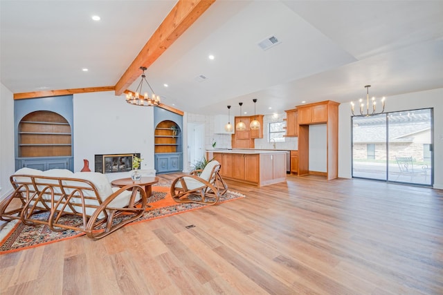 130 Holland Dr, Denison, TX 75020 - living room with a chandelier, light wood-type flooring, a glass covered fireplace, built in features, and recessed lighting