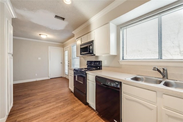 3610 Peakview Dr, Corinth, TX 76210 - kitchen with black appliances, ornamental molding, a textured ceiling, white cabinets, and light wood-style floors