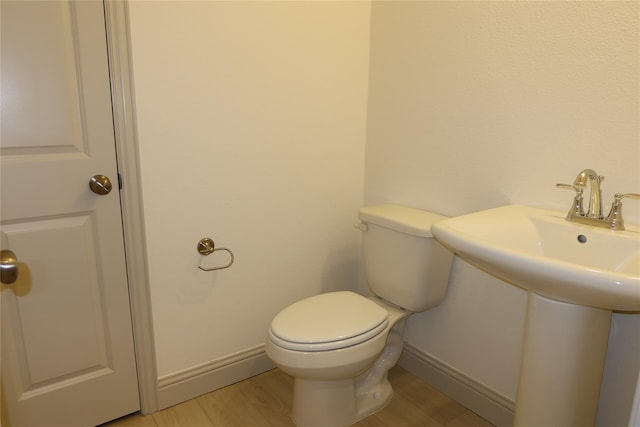 2538 Settlers Pl, Garland, TX 75042 - half bath featuring toilet, baseboards, and wood finished floors