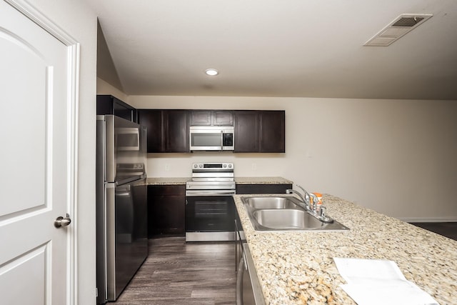 2829 Oakdale St, Dallas, TX 75215 - kitchen with stainless steel appliances, a sink, light countertops, recessed lighting, and dark brown cabinetry