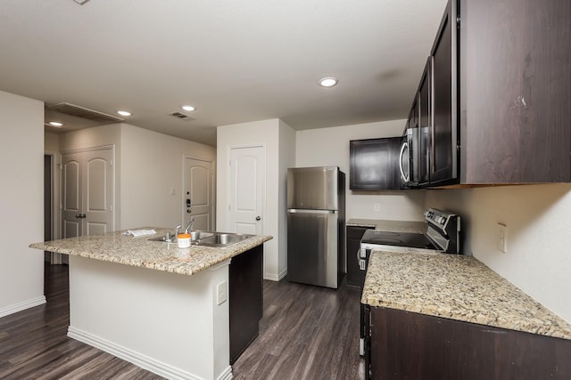 2829 Oakdale St, Dallas, TX 75215 - kitchen featuring appliances with stainless steel finishes, a sink, dark wood-type flooring, baseboards, and an island with sink