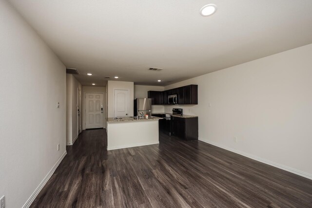 2829 Oakdale St, Dallas, TX 75215 - kitchen featuring stainless steel appliances, dark wood-style floors, a center island with sink, recessed lighting, and baseboards
