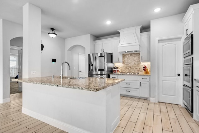 1417 Stoneleigh Pl, Aubrey, TX 76227 - kitchen with appliances with stainless steel finishes, arched walkways, custom exhaust hood, a sink, and recessed lighting
