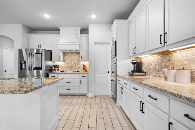 1417 Stoneleigh Pl, Aubrey, TX 76227 - kitchen featuring stainless steel appliances, custom exhaust hood, backsplash, white cabinets, and recessed lighting