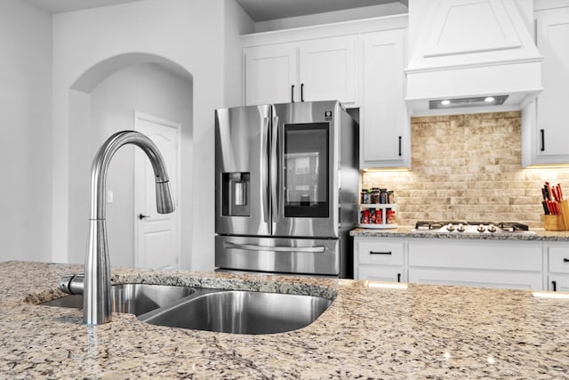 1417 Stoneleigh Pl, Aubrey, TX 76227 - kitchen featuring stainless steel fridge, custom range hood, a sink, gas stovetop, and light stone countertops