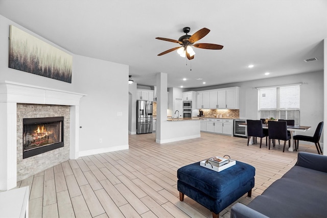 1417 Stoneleigh Pl, Aubrey, TX 76227 - living area featuring ceiling fan, wine cooler, recessed lighting, a glass covered fireplace, and baseboards