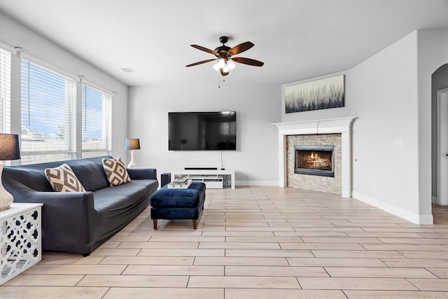 1417 Stoneleigh Pl, Aubrey, TX 76227 - living area with ceiling fan, a lit fireplace, light wood-style flooring, and baseboards