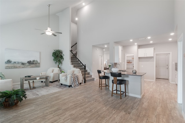 1616 Berry Ridge Trl, Aubrey, TX 76227 - kitchen with high vaulted ceiling, white cabinets, open floor plan, light wood-style floors, and dark countertops