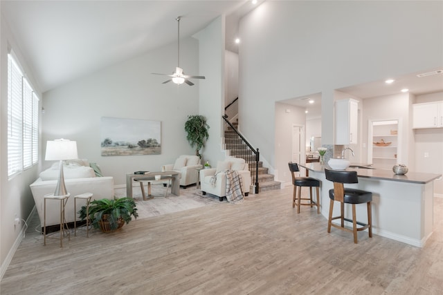 1616 Berry Ridge Trl, Aubrey, TX 76227 - living area featuring stairway, light wood-style flooring, high vaulted ceiling, baseboards, and ceiling fan