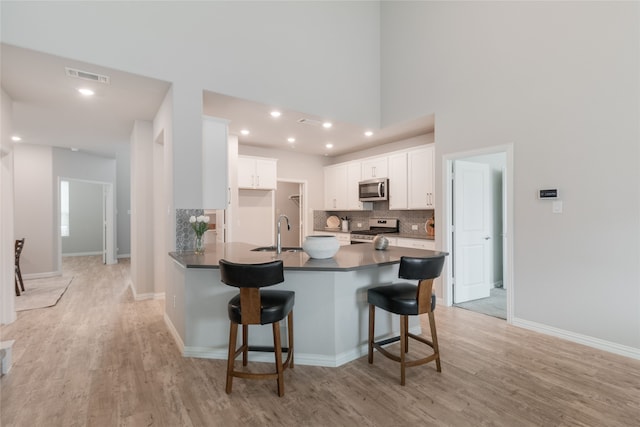 1616 Berry Ridge Trl, Aubrey, TX 76227 - kitchen featuring stainless steel appliances, a sink, dark countertops, decorative backsplash, and a breakfast bar area