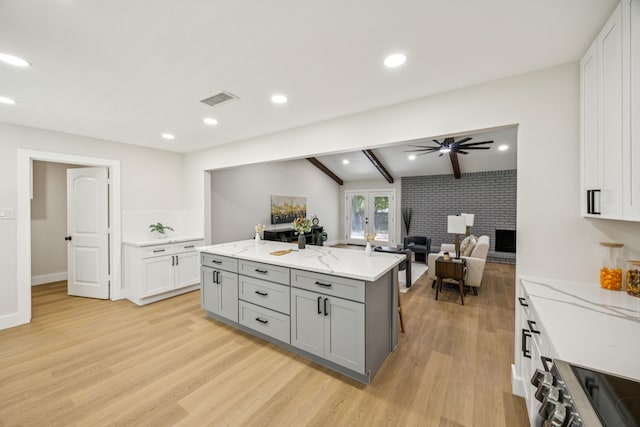 37 Devonshire Dr, Bedford, TX 76021 - kitchen with gray cabinets, light wood finished floors, stove, a ceiling fan, and white cabinetry