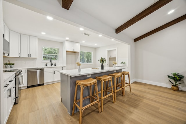 37 Devonshire Dr, Bedford, TX 76021 - kitchen with appliances with stainless steel finishes, light wood finished floors, a sink, white cabinetry, and recessed lighting