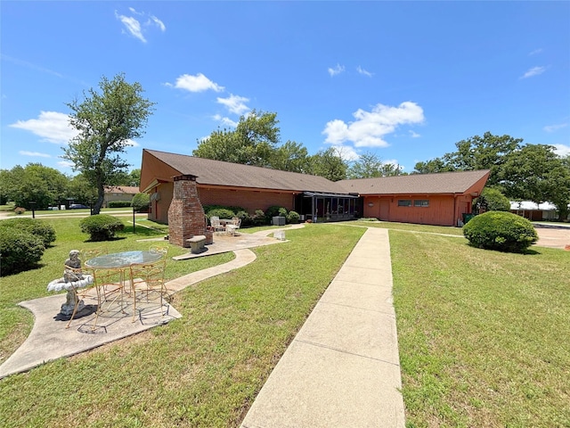905 Bennett Dr, Bowie, TX 76230 - view of front facade featuring a patio, a front yard, and brick siding