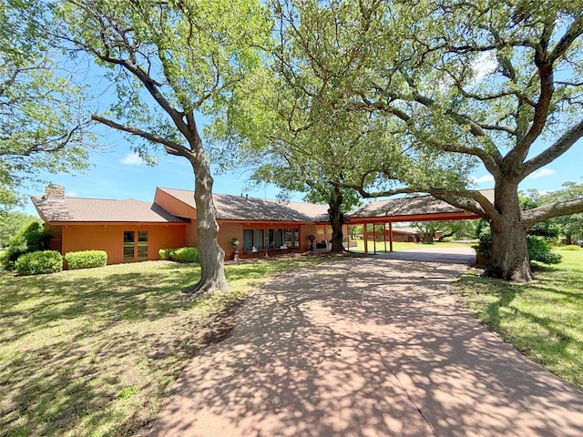 905 Bennett Dr, Bowie, TX 76230 - ranch-style house with concrete driveway, a front lawn, a carport, and a chimney