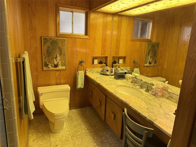905 Bennett Dr, Bowie, TX 76230 - bathroom with toilet, vanity, tile patterned floors, and wood walls
