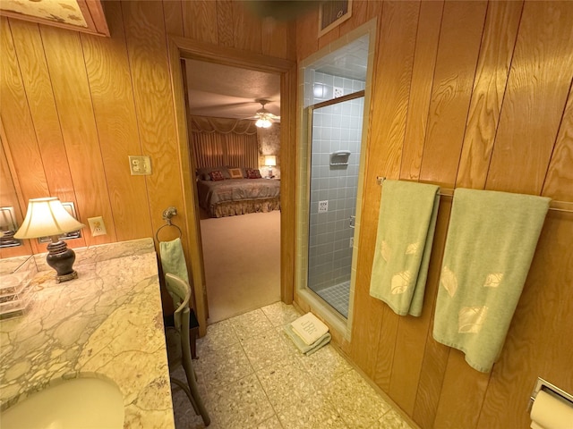 905 Bennett Dr, Bowie, TX 76230 - full bathroom featuring tile patterned floors, a shower stall, wood walls, and a ceiling fan
