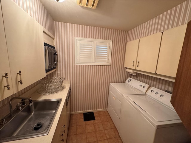 905 Bennett Dr, Bowie, TX 76230 - laundry room featuring wallpapered walls, cabinet space, washer and clothes dryer, light tile patterned floors, and baseboards