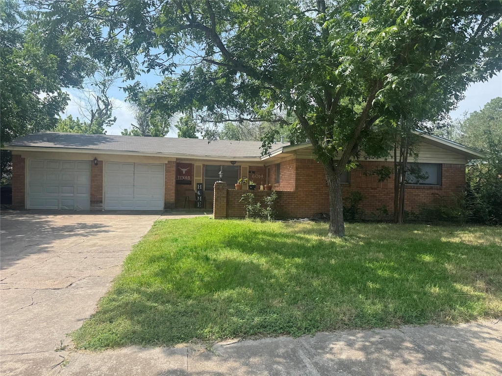 6014 Caldwell, Waco, TX 76710 - ranch-style house featuring an attached garage, driveway, brick siding, and a front lawn