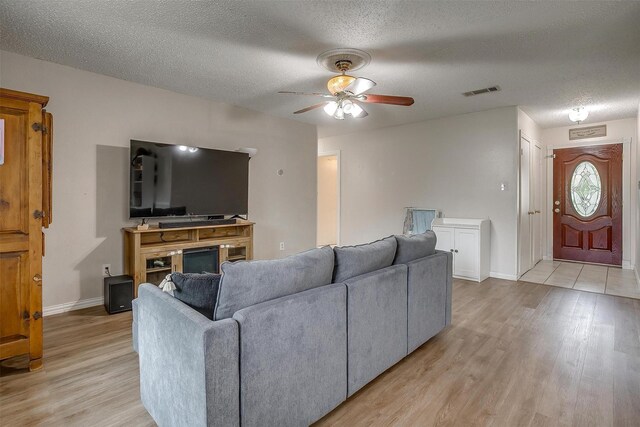 423 Parkview Dr, Burleson, TX 76028 - living room with a ceiling fan, a textured ceiling, light wood finished floors, and baseboards
