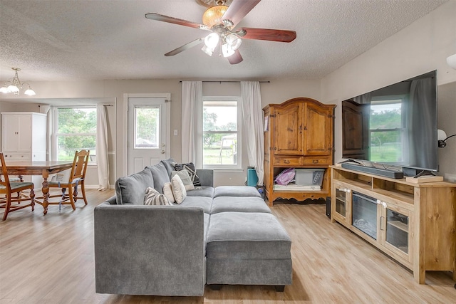 423 Parkview Dr, Burleson, TX 76028 - living room featuring a textured ceiling, light wood-type flooring, plenty of natural light, a chandelier, and ceiling fan
