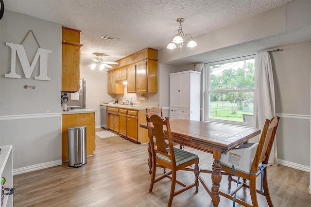 423 Parkview Dr, Burleson, TX 76028 - dining area with light wood-style floors, a textured ceiling, baseboards, a chandelier, and a ceiling fan