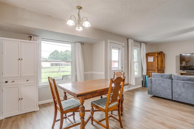 423 Parkview Dr, Burleson, TX 76028 - dining area with a textured ceiling, light wood-style flooring, a chandelier, and baseboards