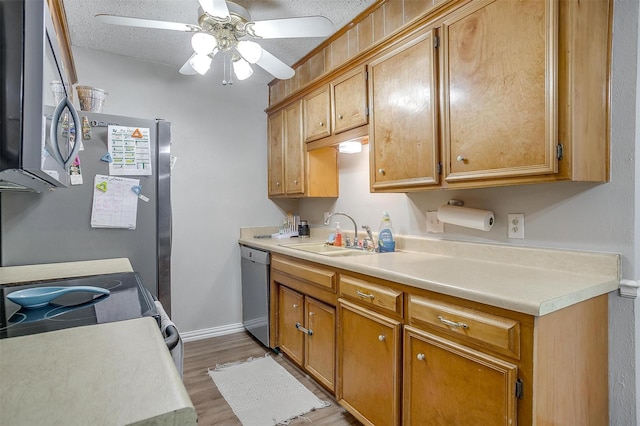 423 Parkview Dr, Burleson, TX 76028 - kitchen with appliances with stainless steel finishes, a sink, ceiling fan, light countertops, and light wood-type flooring