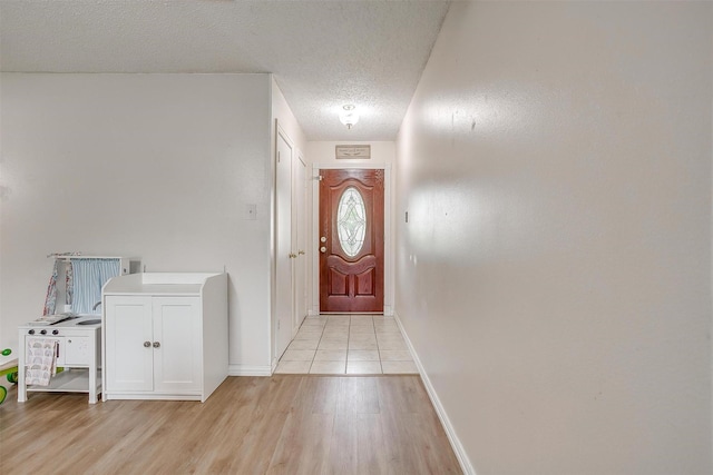423 Parkview Dr, Burleson, TX 76028 - entryway featuring light wood-style flooring, a textured ceiling, and baseboards